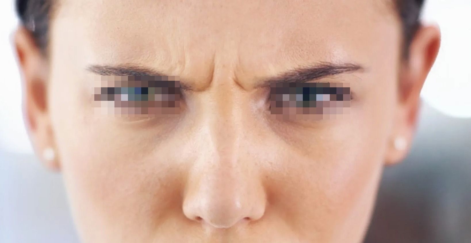 Close-up of a person's furrowed brow and blurred eyes, expressing emotion.