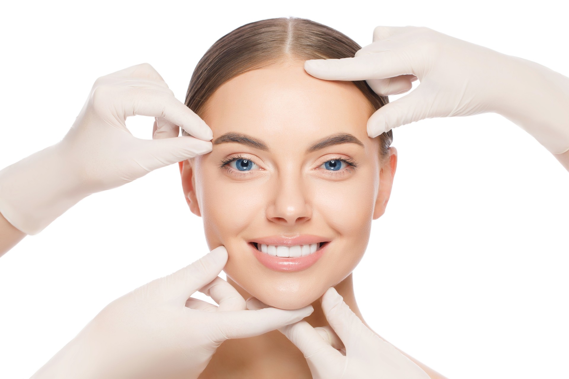 Young smiling woman touched by doctors in gloves, preparing for plastic surgery, isolated on white background